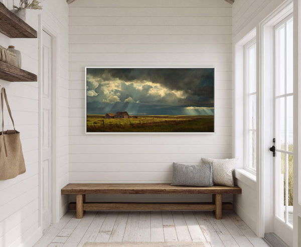This horizontal canvas print displays a dramatic landscape with a dark, stormy sky over rustic barns in a field, rendered in a realistic style with a muted palette, hanging on.