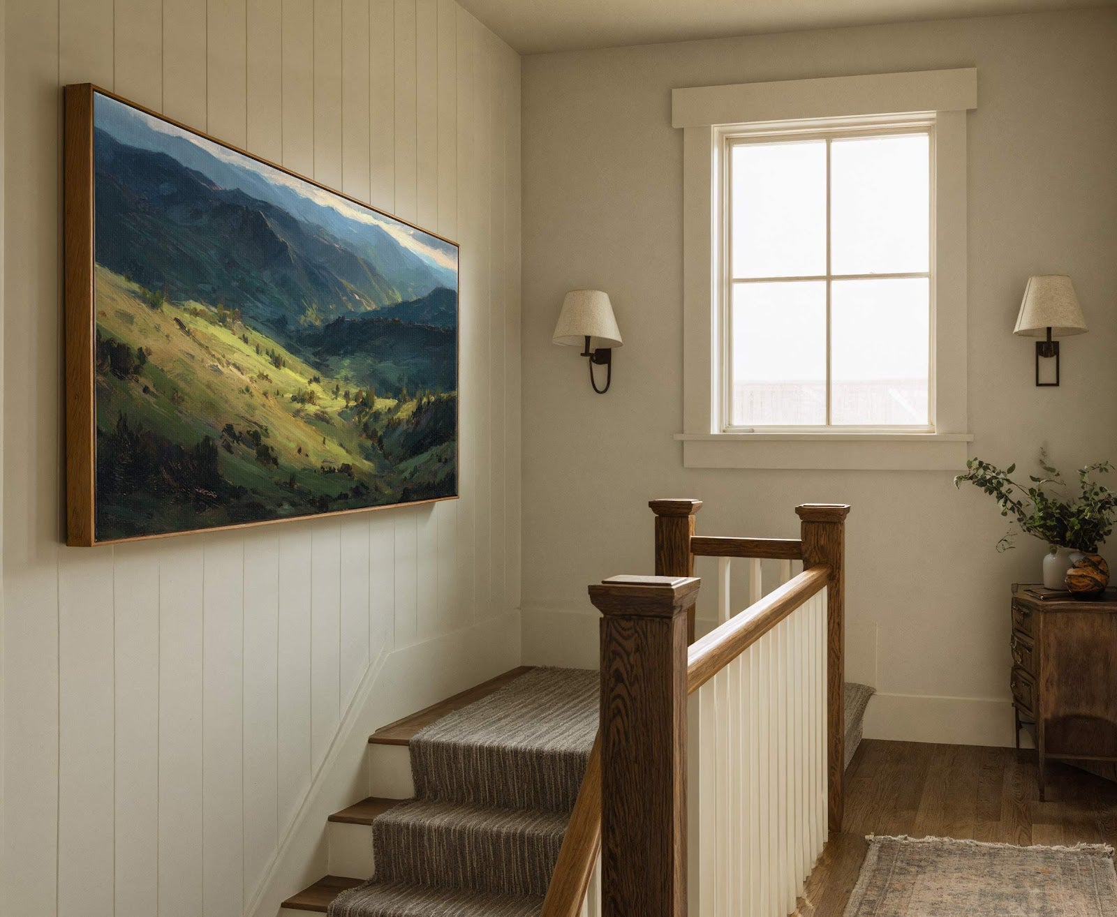 This horizontal landscape painting print, featuring a vibrant green and blue palette, is framed in natural wood and hangs on a wood-paneled wall above a staircase with a striped runner.