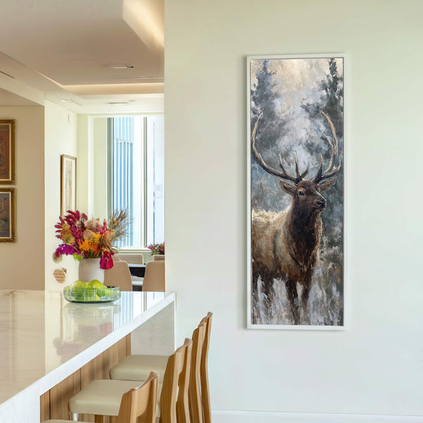 This vertical, framed canvas print features an oil painting of an elk in a forest setting with a muted, earthy palette. The artwork hangs on a white wall in a.