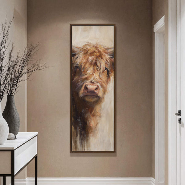 This vertical canvas wall art features a Highland cow portrait with a warm, earthy palette and impressionistic style, displayed in a room with a taupe wall and a console table.