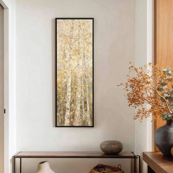 This vertical, impressionistic art print depicts birch trees with a warm, autumnal palette against a neutral wall, displayed above a wooden console table.
