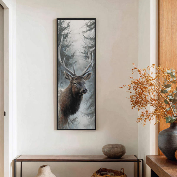 This vertical canvas wall art features a realistic painting of a majestic elk with large antlers, set against a misty forest background. The artwork is framed in black and hangs.