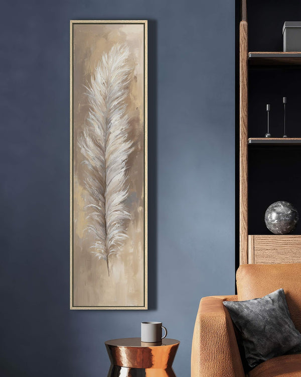 This vertical painting print features a white feather in a textured beige palette, displayed in a gold floater frame on a dark blue living room wall near an orange sofa.
