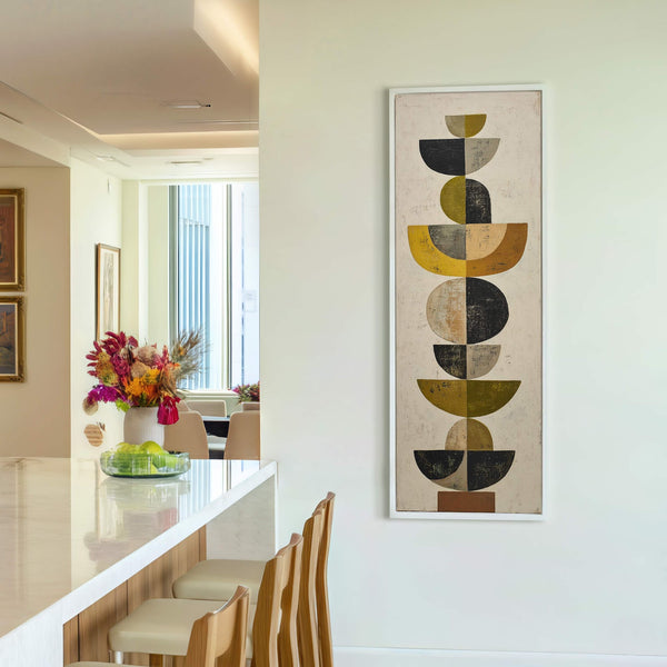 This vertical canvas wall art features a mid-century modern abstract style with a palette of mustard yellow, olive green, black, and beige, displayed on a white wall above a console.