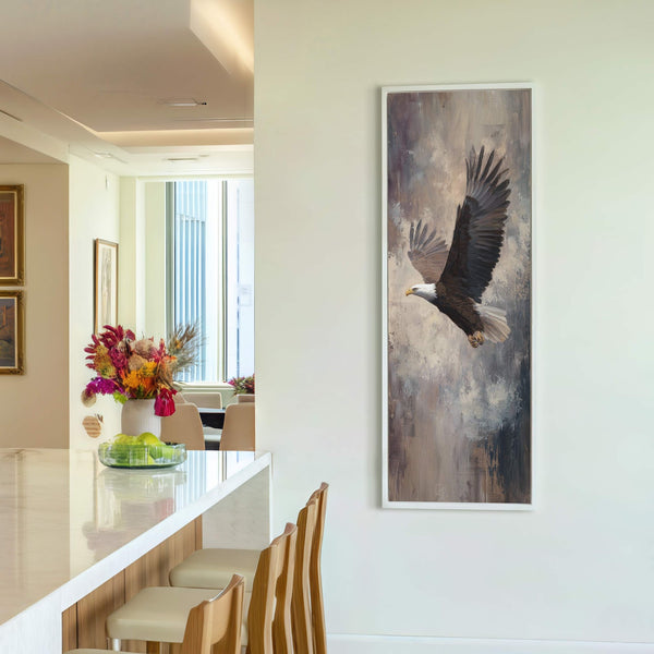 This vertical canvas wall art features an eagle in flight with a muted, textured background in browns and grays, displayed on a white wall next to a bar with stools.
