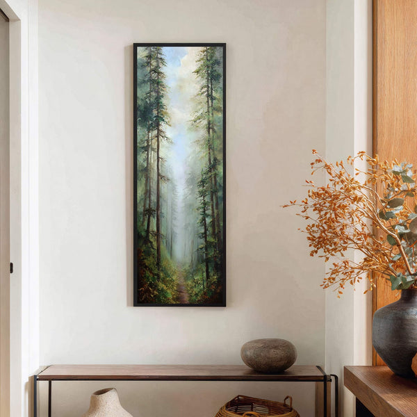 This vertical, impressionist-style art print depicts a misty forest path with tall pine trees. The palette features deep greens, blues, and browns. It is displayed on a textured off-white wall.