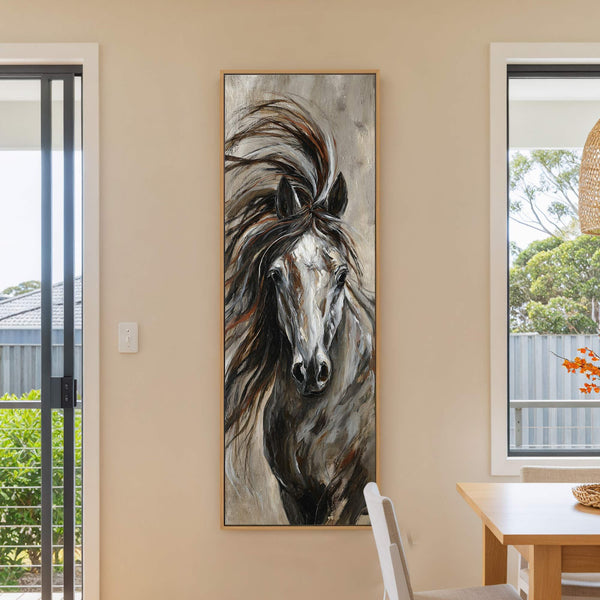 This vertical canvas wall art features a textured painting of a horse with a palette of browns, grays, and whites, framed in natural wood, displayed on a beige wall next.