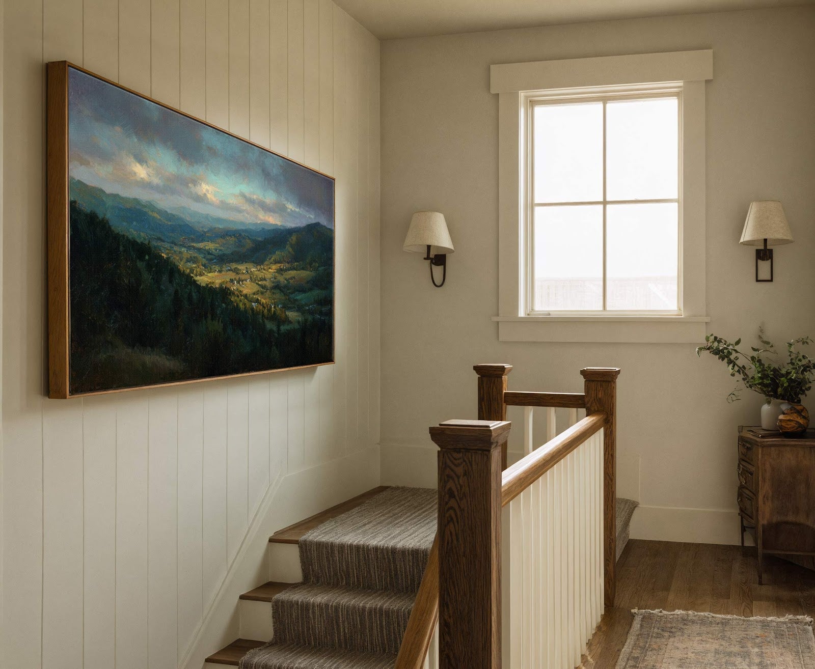 This horizontal canvas wall art depicts a dramatic landscape with a rich palette of blues and greens, framed in natural wood. It is displayed above a staircase with paneled walls.