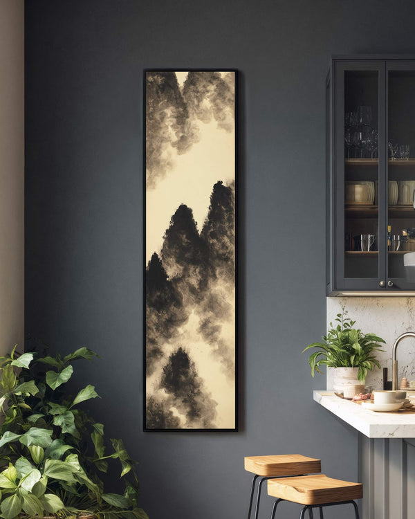 This vertical canvas art print features a monochromatic ink-wash mountain landscape in a black floater frame, hanging on a dark gray kitchen wall next to a glass-front cabinet.