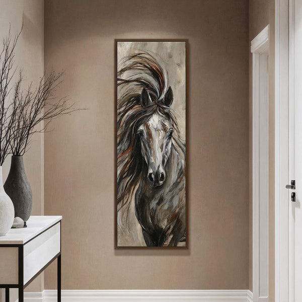 This vertical canvas wall art depicts a powerful horse with a dark, textured palette and painterly style, framed in dark wood and displayed on a tan wall above a console.