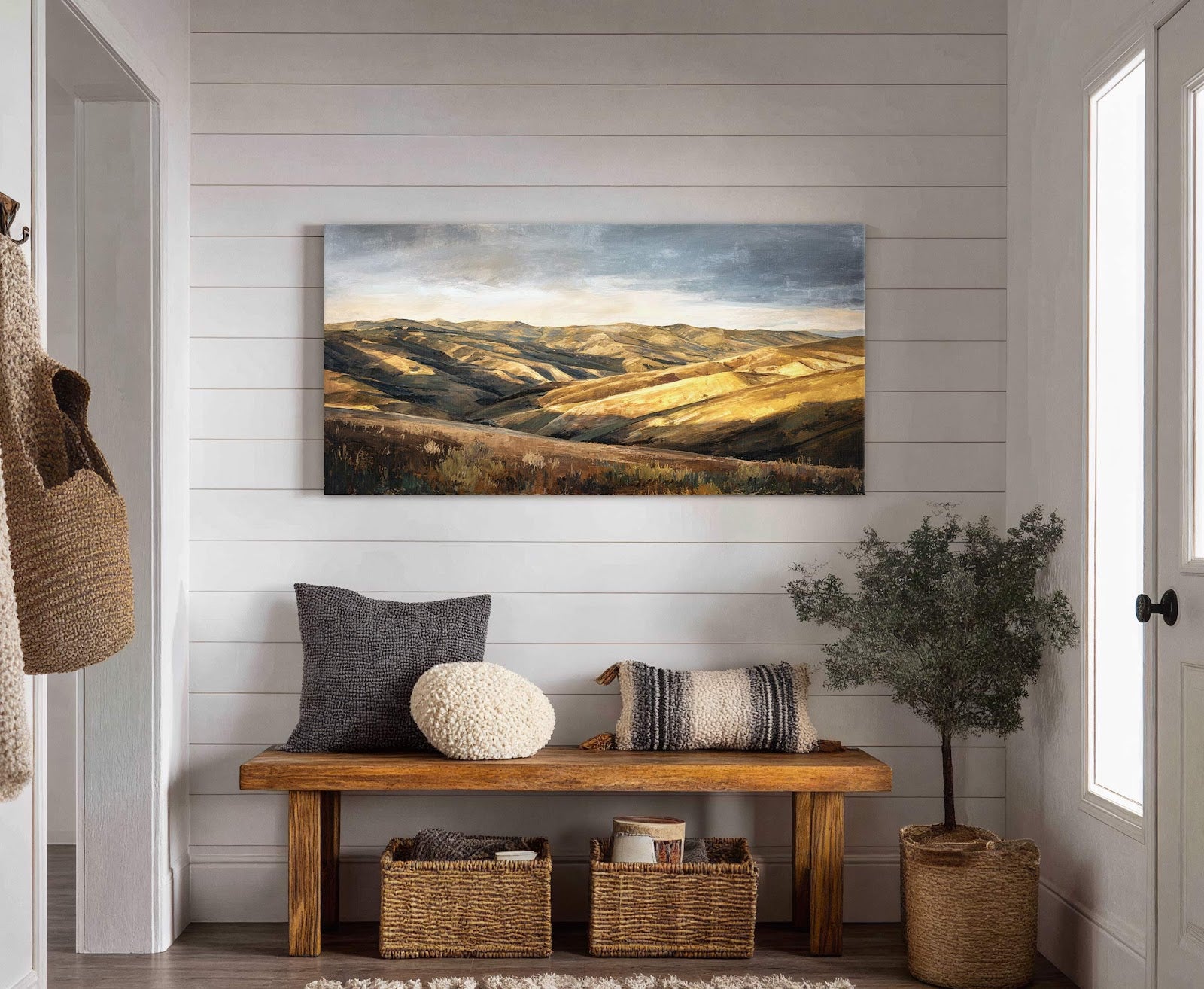 This horizontal canvas wall art features rolling hills in a golden and green palette, rendered in a painterly style. It is displayed on a white paneled wall above a wooden.