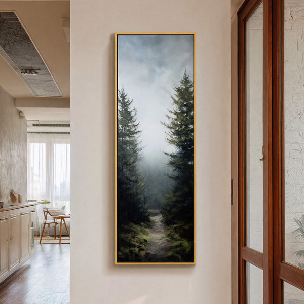 Vertical canvas wall art depicting a foggy forest path with dark green trees and a muted palette, displayed on a neutral wall next to a wooden door frame.