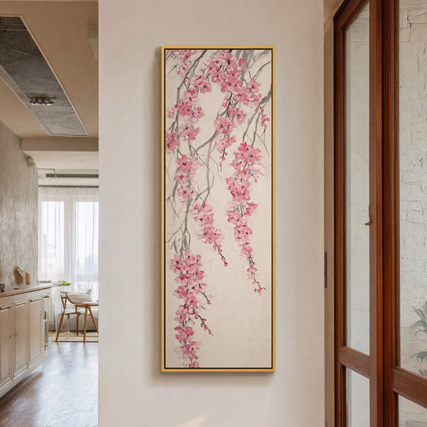 This vertical canvas print features a delicate watercolor-style painting of pink cherry blossoms cascading down thin branches against a muted beige background, framed in gold.