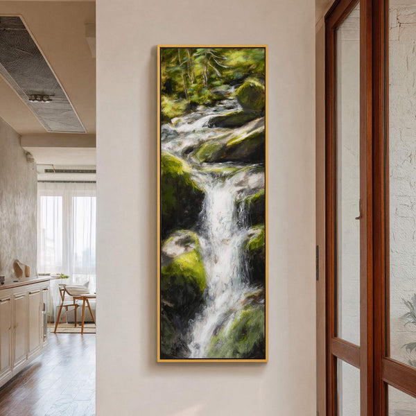 This vertical, impressionistic canvas wall art print depicts a lush green forest waterfall with a vibrant palette. It is framed in gold and hangs on a light beige wall near.