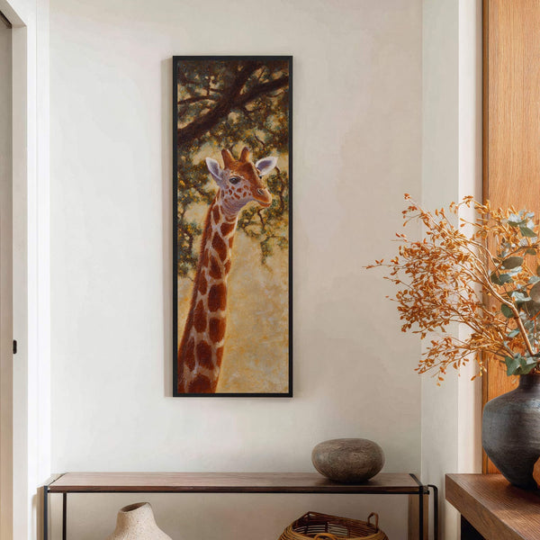 This vertical, framed canvas wall art features a detailed painting of a giraffe head and neck with warm, earthy tones, set against a backdrop of leafy branches, displayed above a.