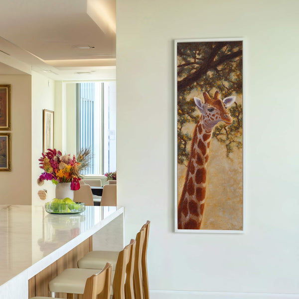 This vertical canvas wall art features a giraffe portrait with warm earthy tones and a textured style, framed in white and hanging on a white wall in a modern room.