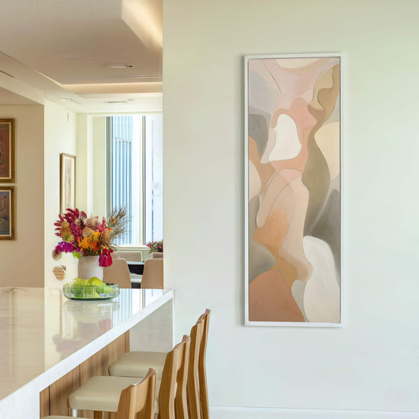 This vertical canvas wall art features an abstract composition in soft, neutral tones of peach, beige, and gray, presented in a white floater frame against a light-colored wall.