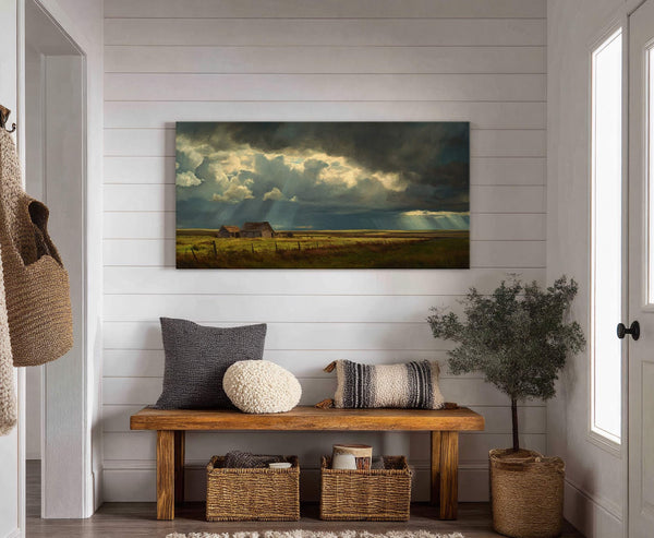 This horizontal canvas print features a dramatic landscape painting of storm clouds over a field with barns, rendered in dark, moody tones with dramatic light rays, displayed on a white.