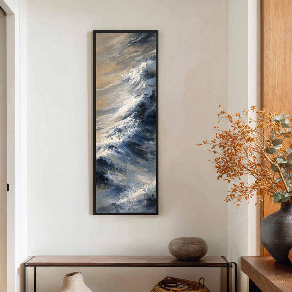 This vertical canvas wall art features an abstract impressionist style, capturing stormy blue and white waves with hints of beige, displayed on a cream wall above a wooden console table.