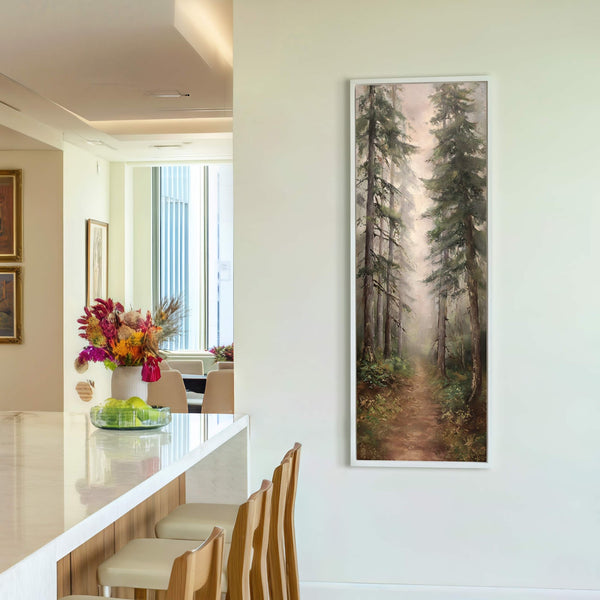 This vertical, impressionistic painting print depicts a misty forest path with tall trees in rich green and brown tones, framed in white and displayed on a light-colored wall near a.