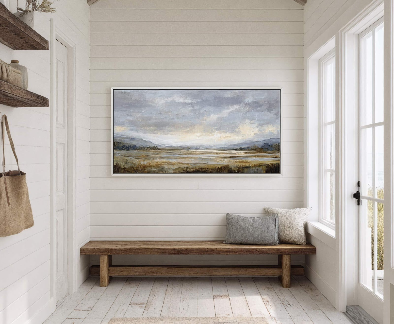 This horizontal canvas wall art features an abstract landscape in a muted palette of grays, blues, and earthy tones, displayed in a white floater frame on white wood-paneled walls above.