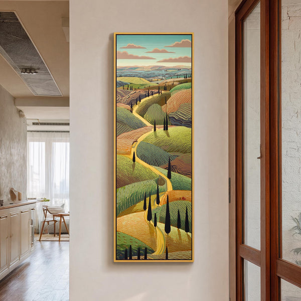 This vertical canvas wall art depicts a vibrant green and gold stylized Tuscan landscape in a gold frame, hanging on a white drywall hallway wall near wooden cabinets.