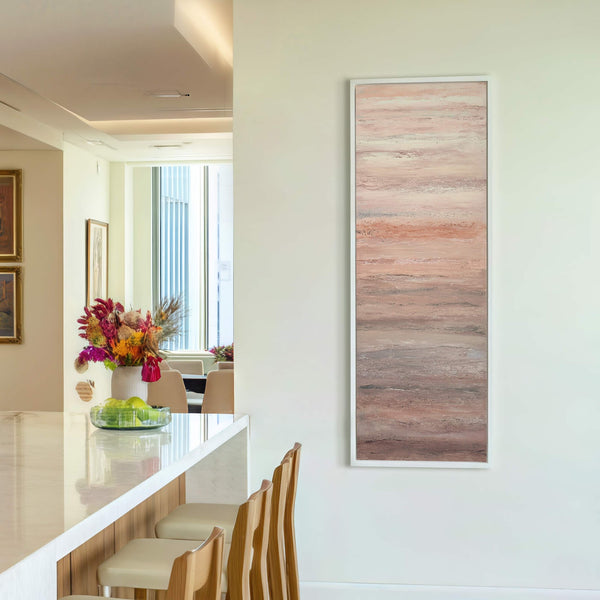 This vertical canvas wall art features an abstract, textured style with a palette of muted pinks, corals, and grays, presented in a white floater frame against a light-colored wall.