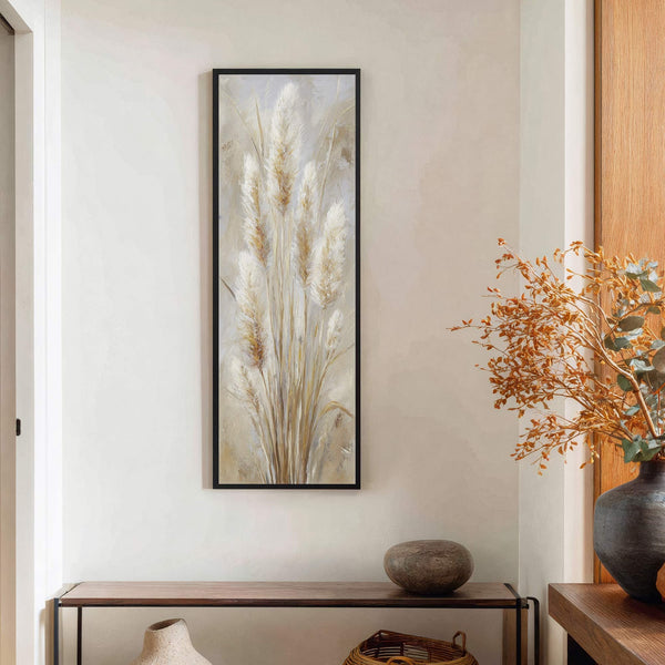 This vertical canvas wall art features pampas grass with a neutral palette and impressionistic style, displayed on a light-colored wall above a wooden console table.