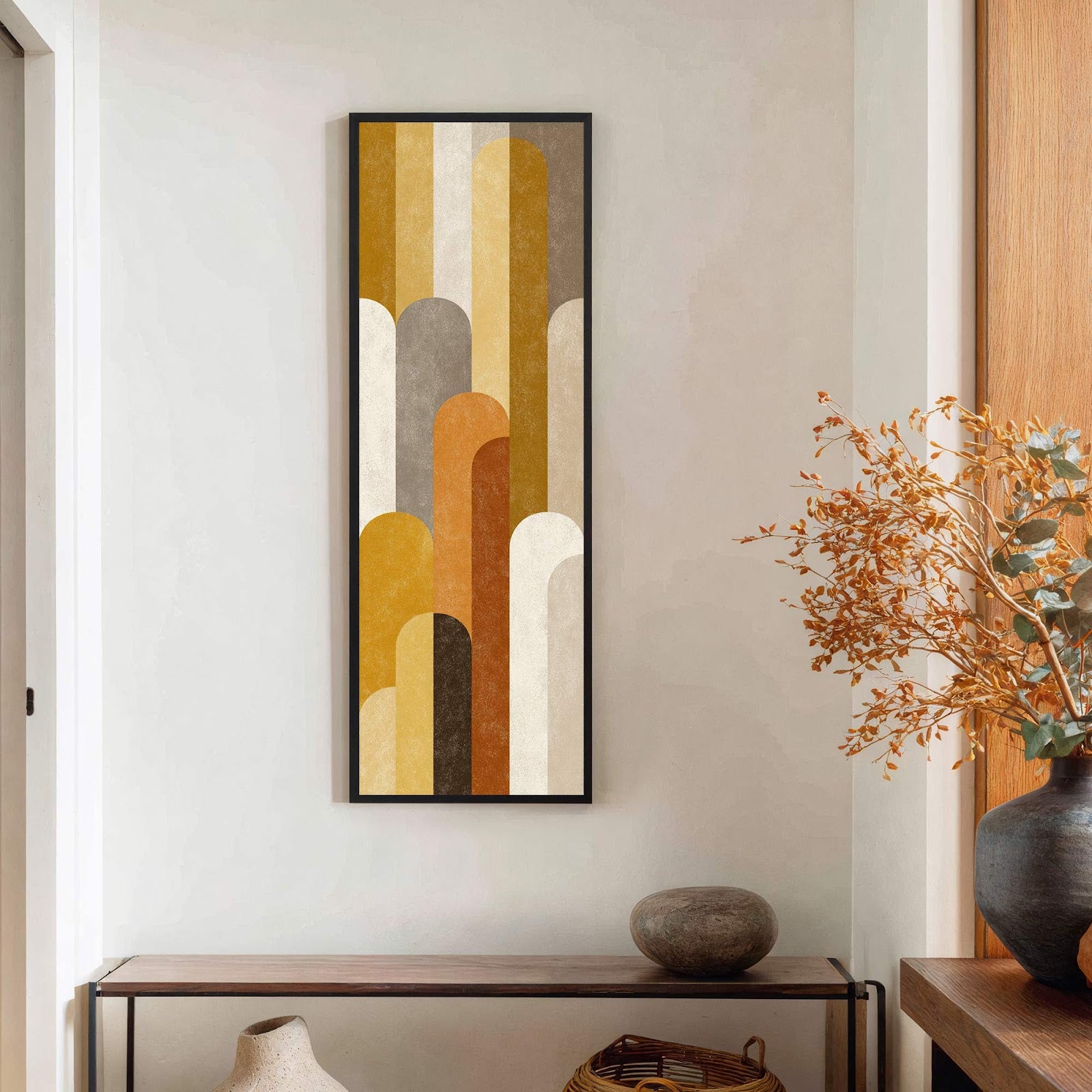This vertical art print features an abstract geometric design with rounded shapes in a warm palette of mustard yellow, brown, and cream, set against a lightly textured off-white wall above.