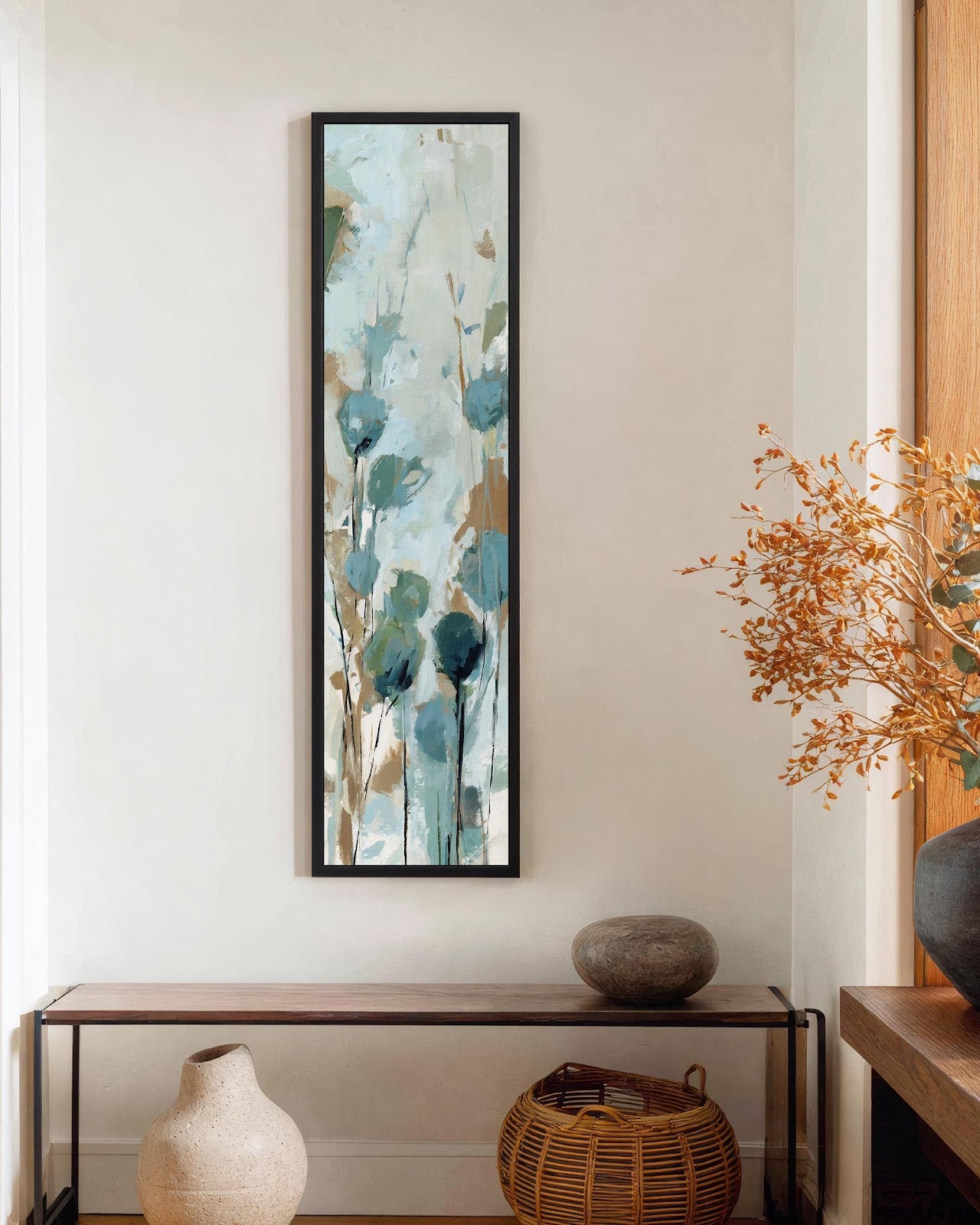 Teal abstract botanical canvas print in black floating frame above wooden console in neutral hallway with natural decor, vertical wall art