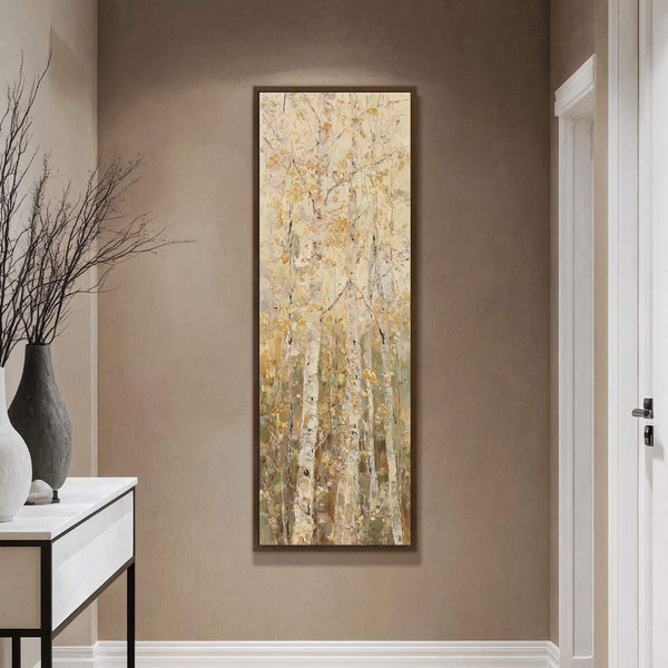 This vertical canvas wall art features an impressionistic forest scene with pale yellow and white birch trees. It is framed in a dark wood and hangs on a taupe wall.