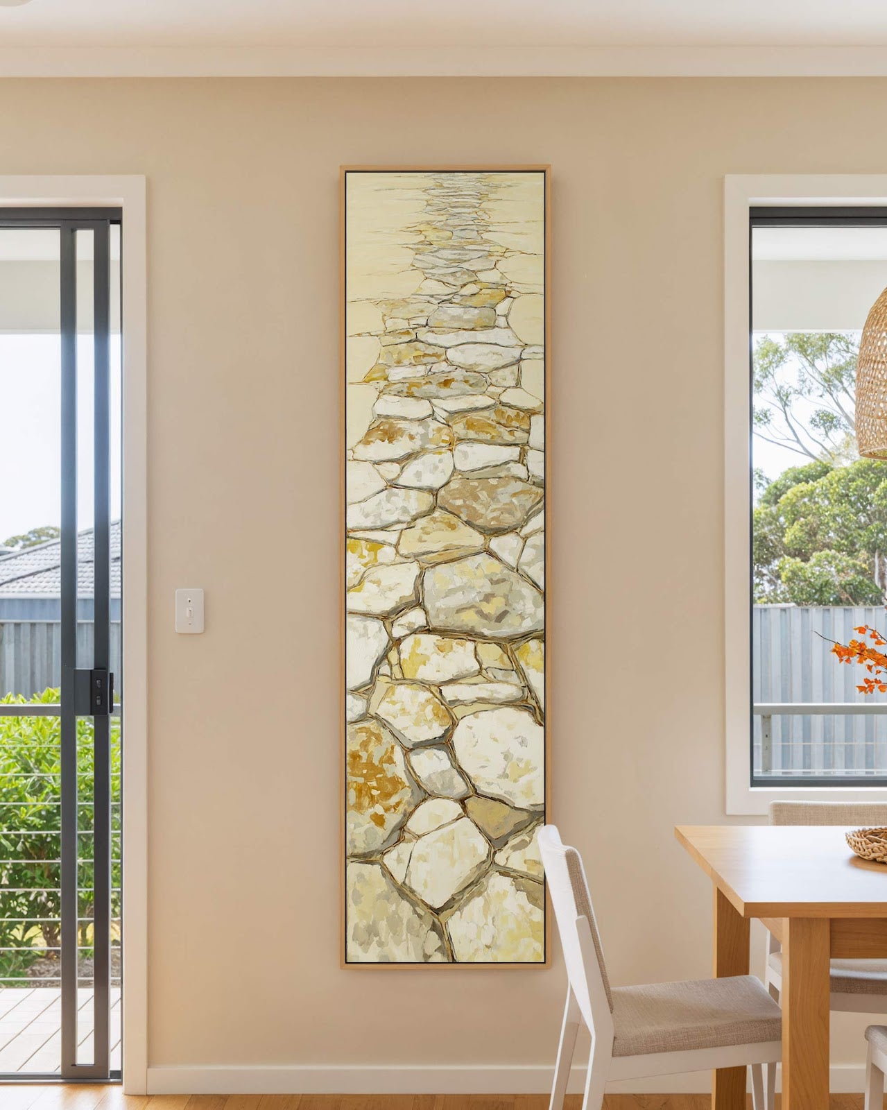 Vertical canvas wall art in interior setting.
