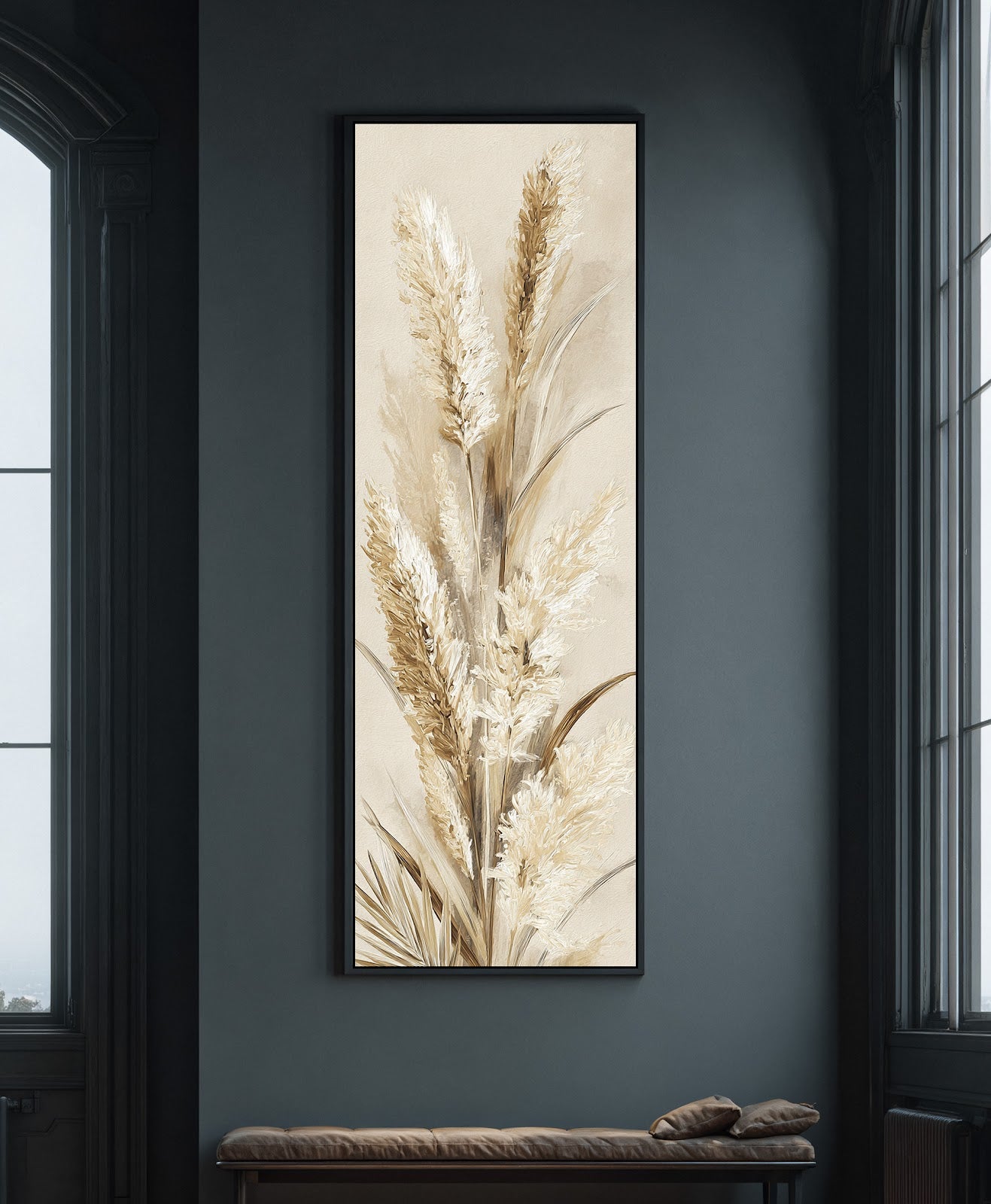 This vertical canvas wall art depicts textured pampas grass in neutral beige tones, framed in a black floater frame on a dark gray wall above a leather bench.