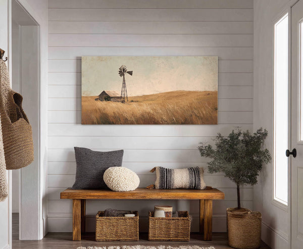 This horizontal canvas print features a rustic landscape with a windmill and barn set in a golden field, rendered in muted tones. It is displayed on a white planked wall.