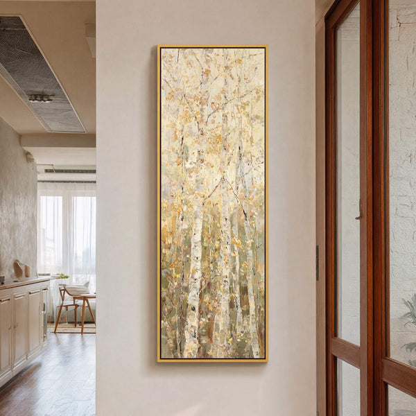 This vertical canvas wall art depicts an impressionistic forest scene with a warm, muted palette and textured brushstrokes, framed in gold, hanging on a plain wall in a room with.