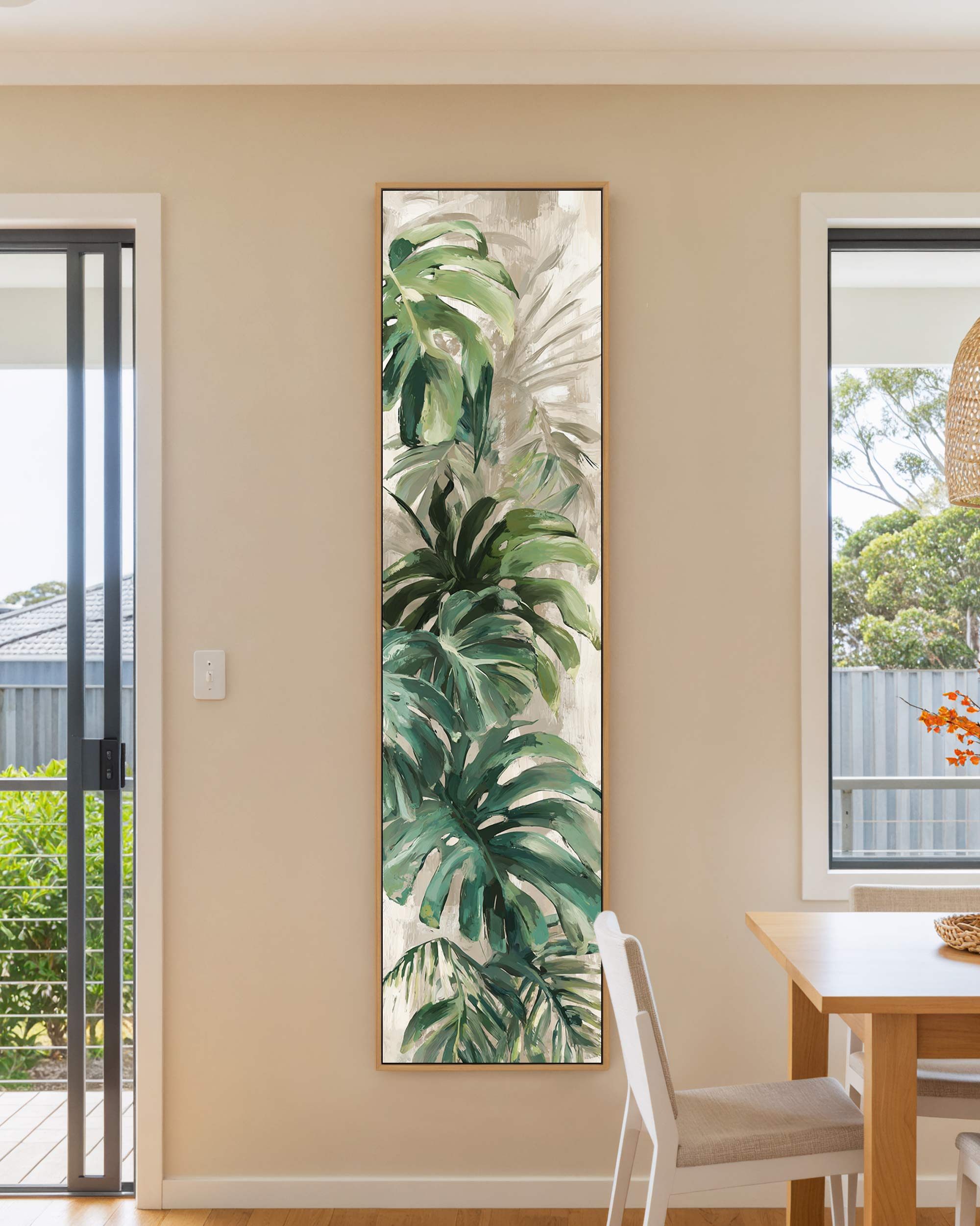 Tall vertical framed canvas wall art featuring a moody, vintage-style pine tree forest illustration in earthy sepia and brown tones, hanging on a warm beige wall.