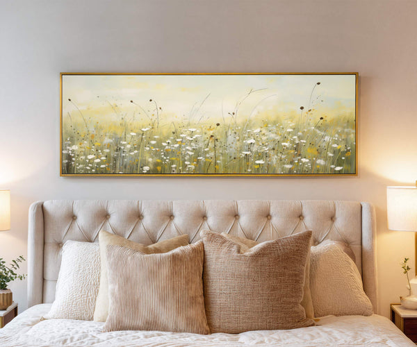 Floral canvas wall art framed above a tufted beige bed with neutral pillows and warm lighting in a cozy bedroom interior