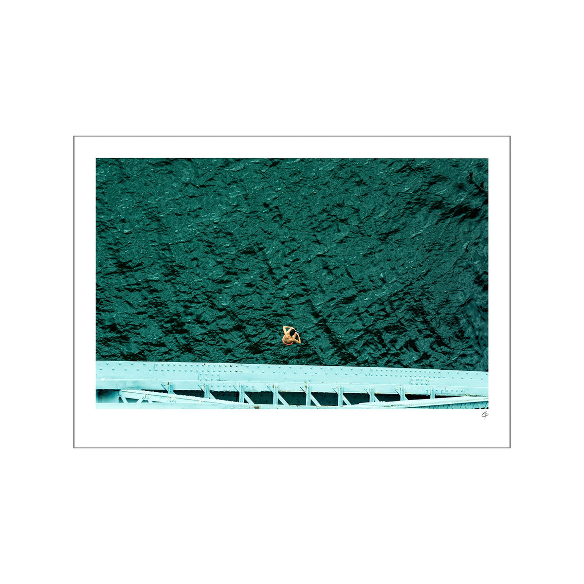 Lone diver above dark teal water with a pale bridge edge along the bottom