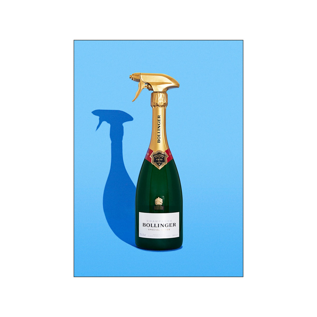 Champagne bottle topped with a gold spray nozzle on a bright blue background