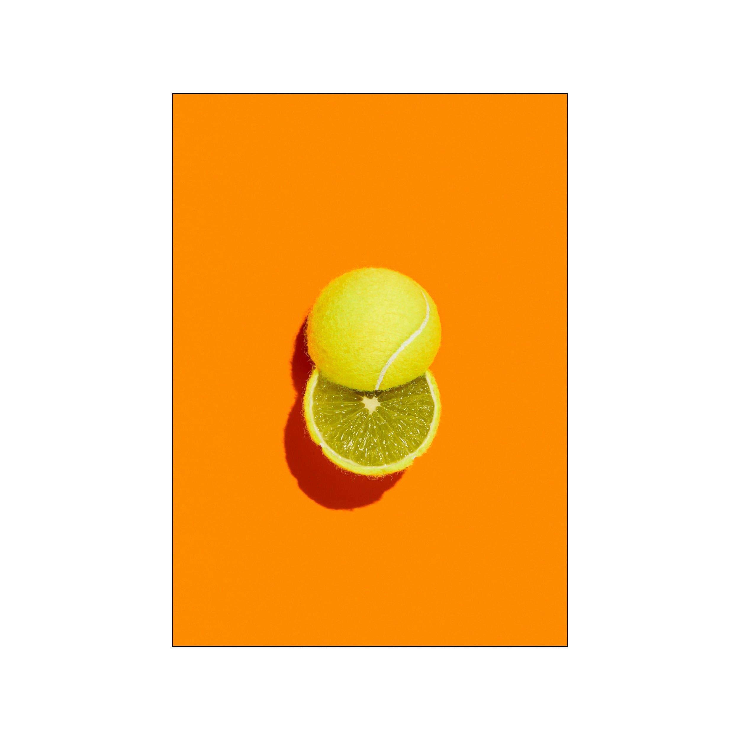A tennis ball stacked on a lime slice against a vivid orange background