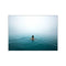 A lone swimmer with their back to the viewer glides through calm, deep blue ocean waters under a hazy, light-filled sky, embodying a feeling of peaceful solitude.