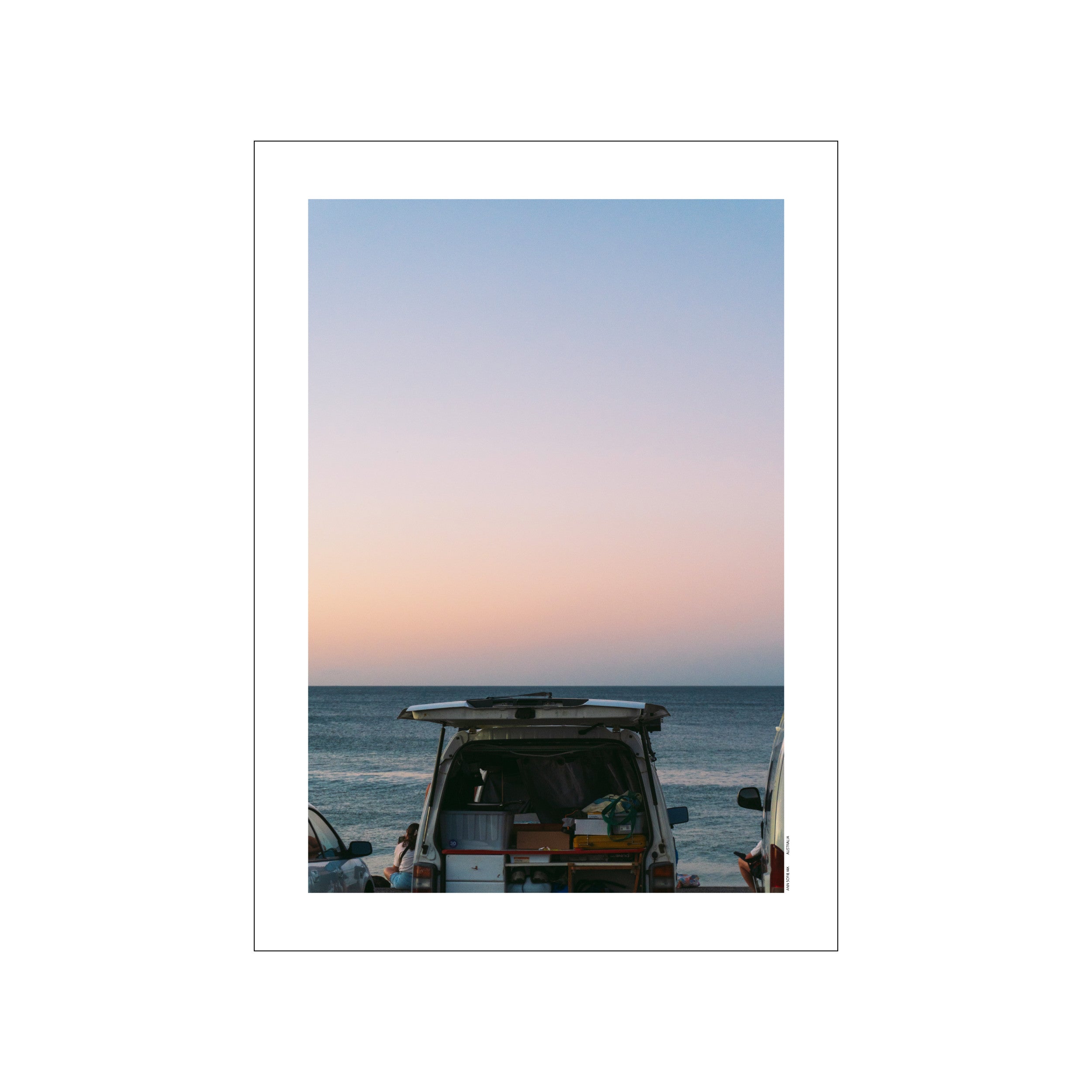 A vintage camper van parked by the ocean at sunset, with its rear doors open, under a soft gradient sky of blue and pink hues, evoking a serene and adventurous coastal vibe.