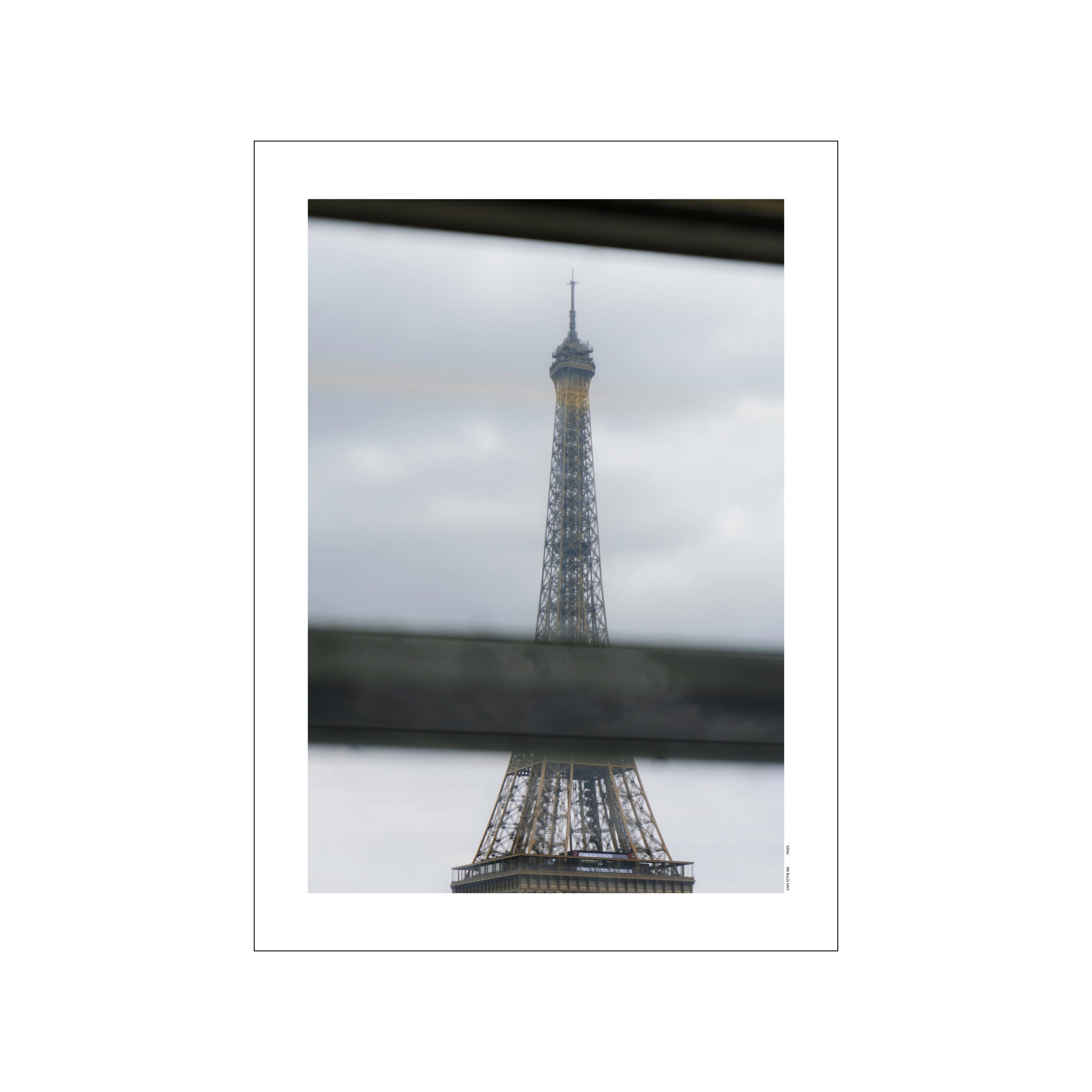 The Eiffel Tower viewed through a train window, framed by blurred horizontal bars, against a soft, cloudy sky. The artwork has a muted, elegant palette.