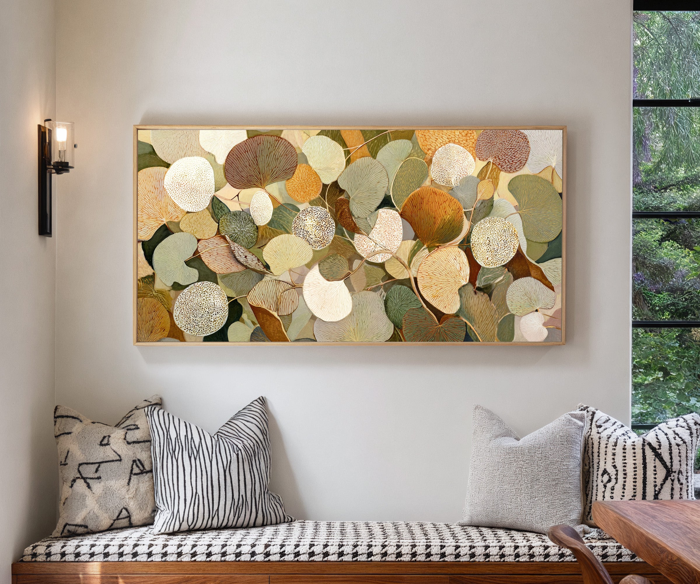 rounded leaf forms in olive, cream, gold, rust, canvas wall art in a natural wood frame in a living room