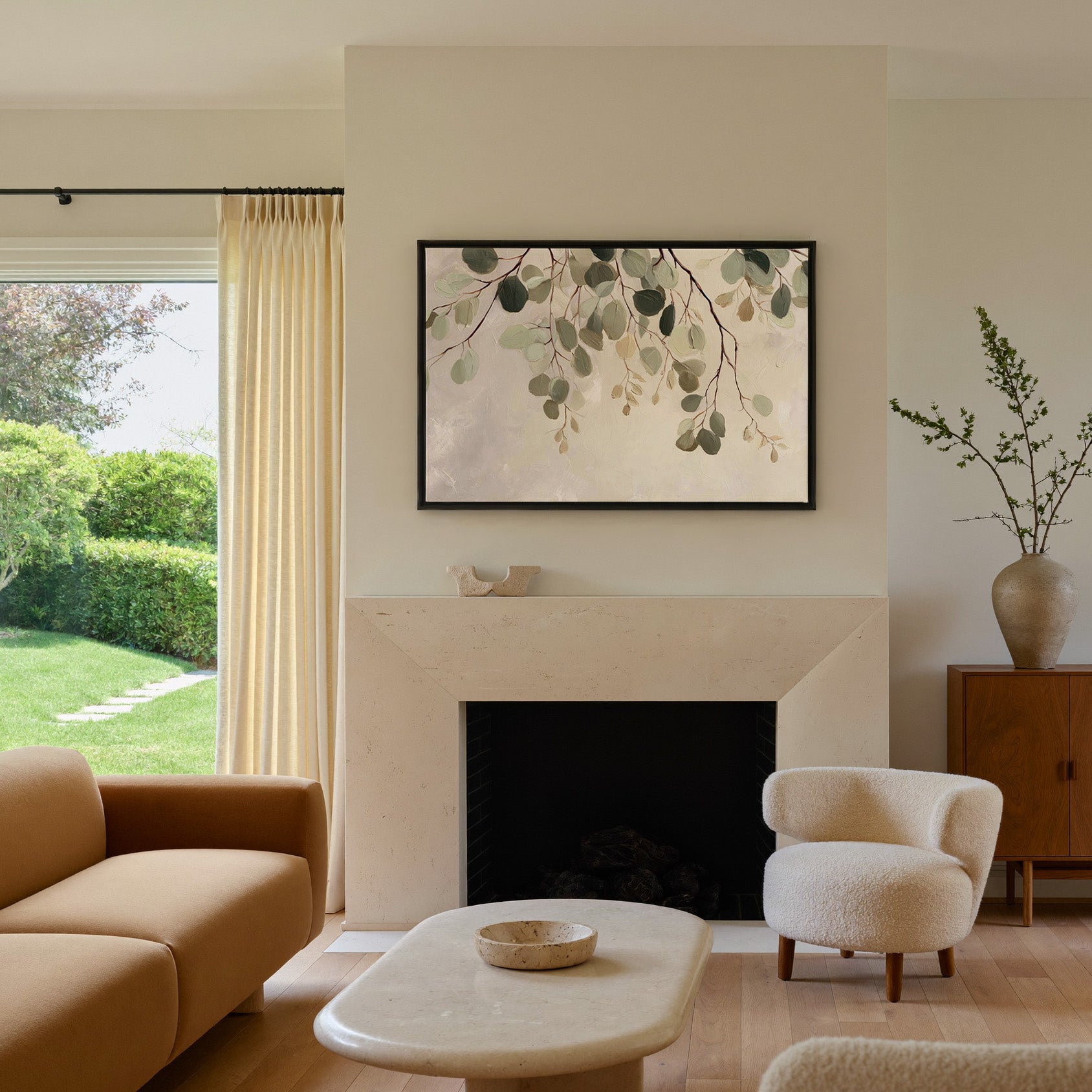 airy eucalyptus leaves on pale ground canvas wall art in a black frame above a mantel