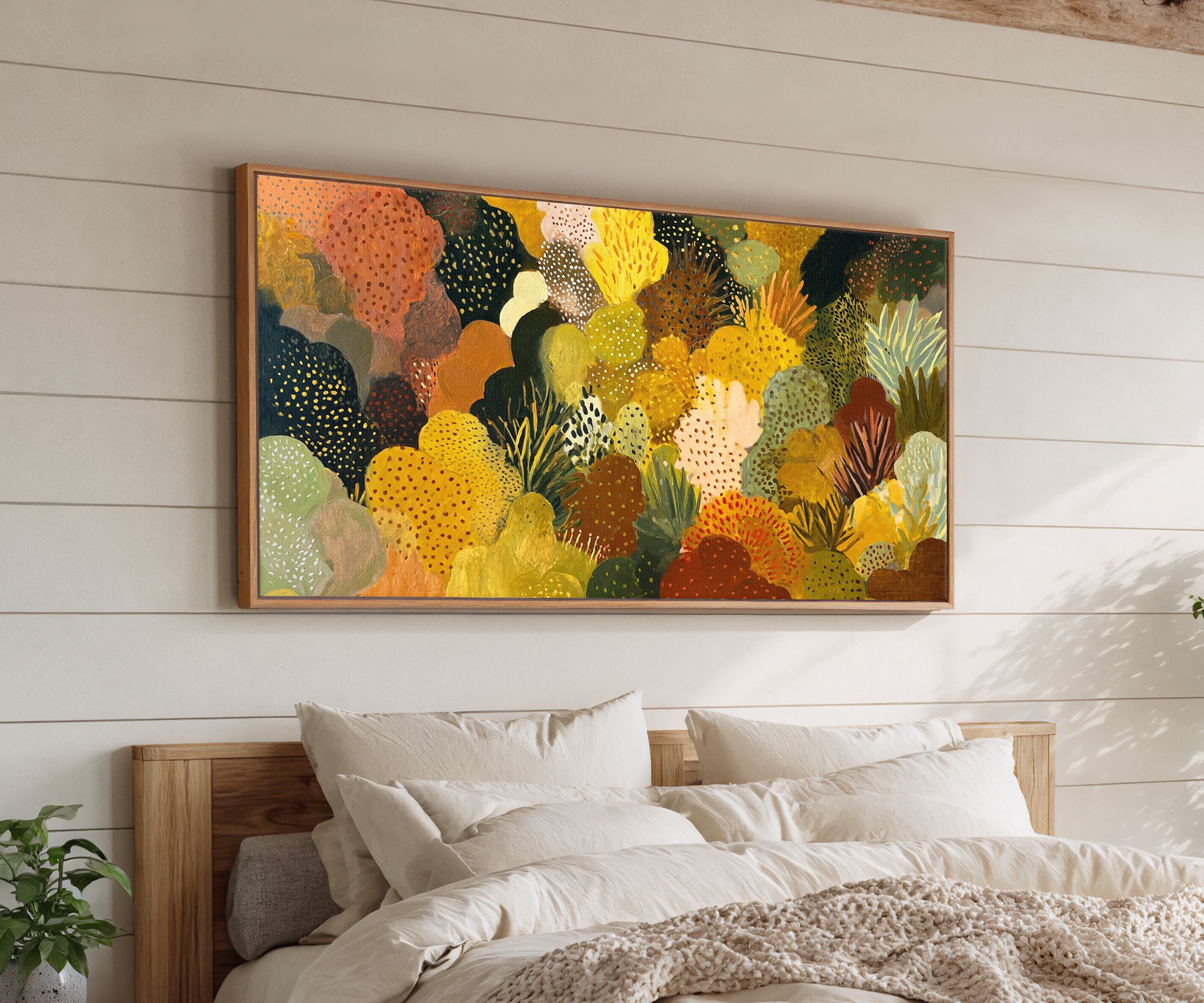 dense ochre and terracotta abstract canvas wall art in an oak frame above a bed