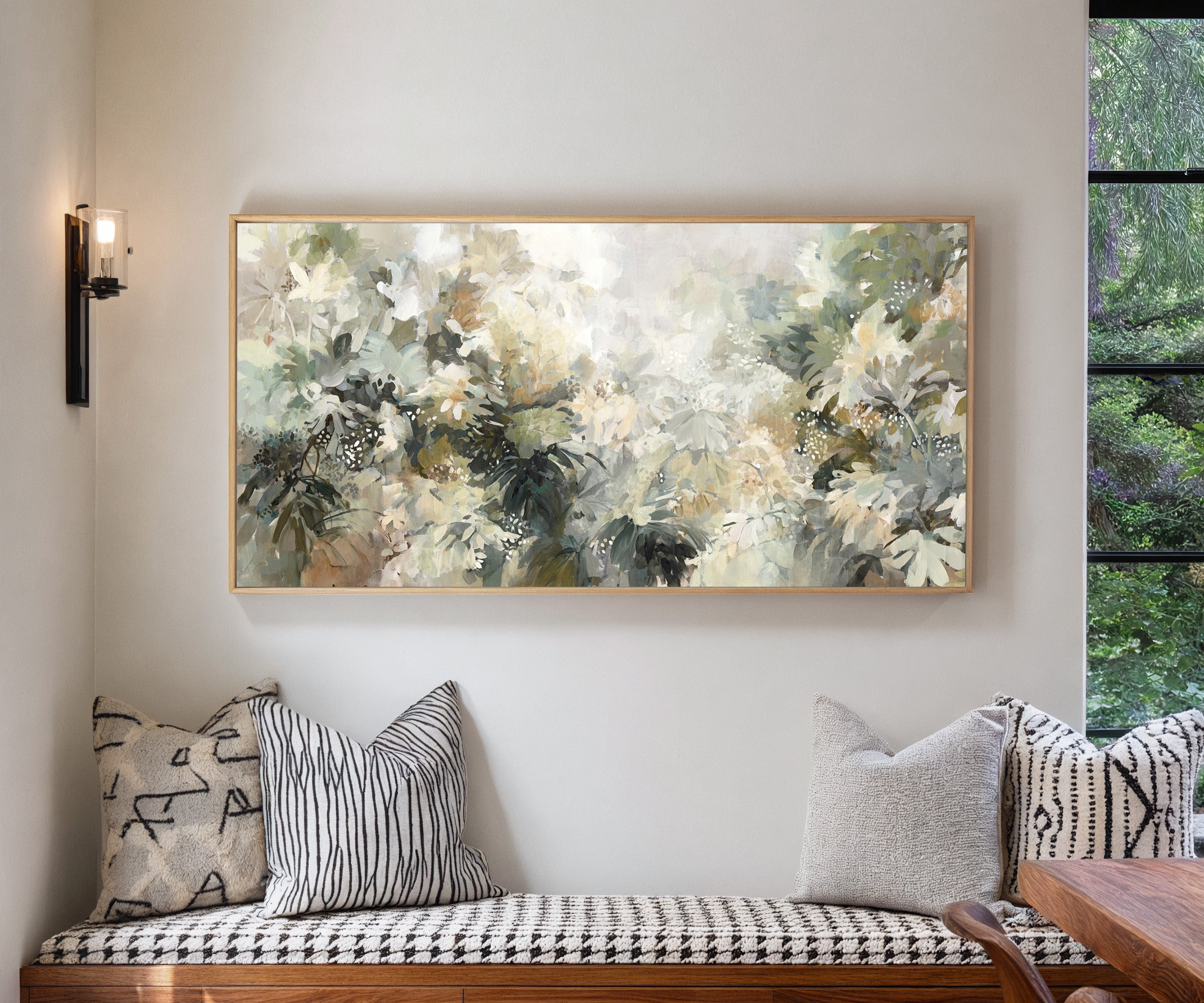soft layered foliage in cream, sage, olive, and canvas wall art in a natural wood frame in a living room
