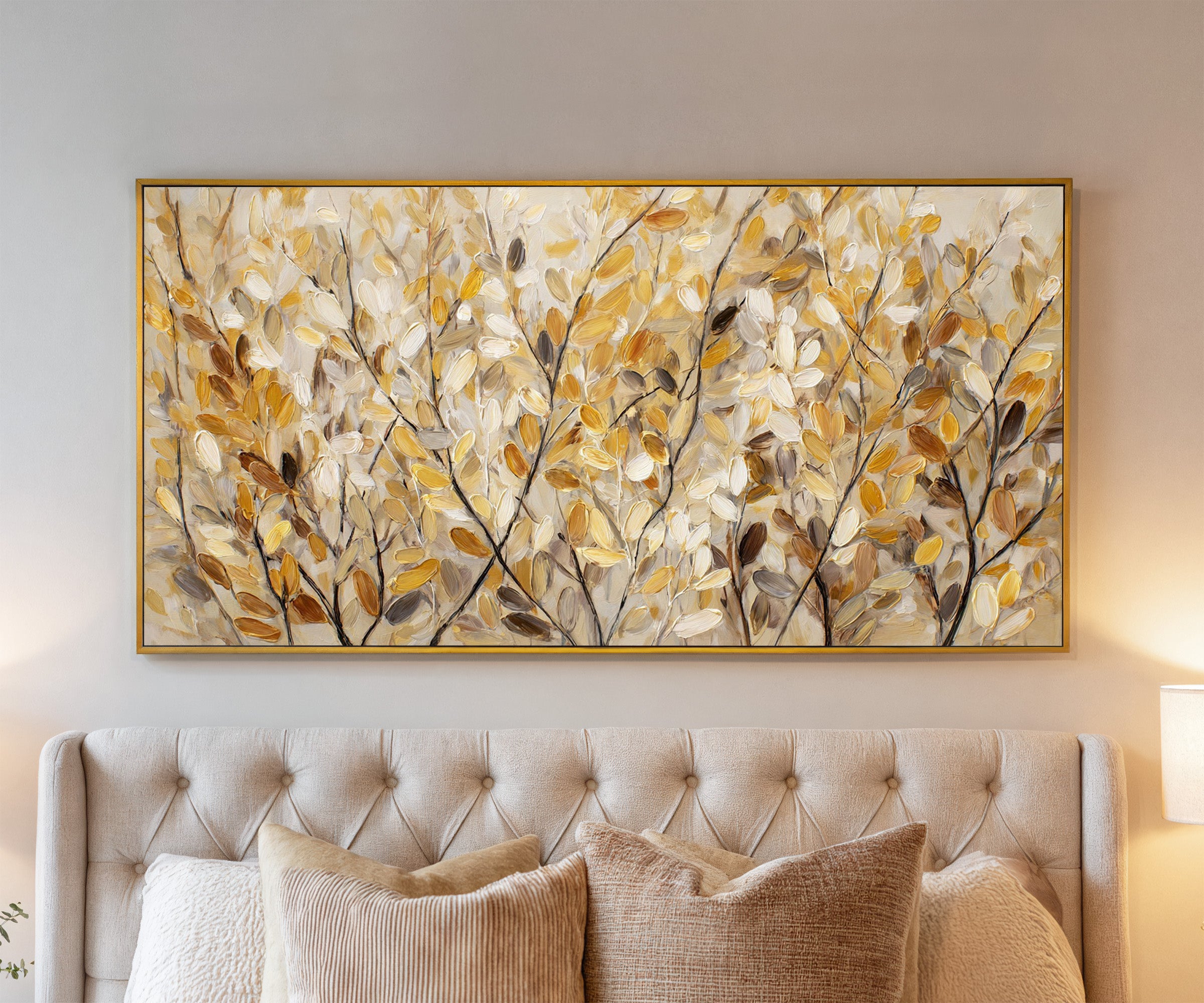 golden leaves and dark branching stems canvas wall art in a gold frame above a bed