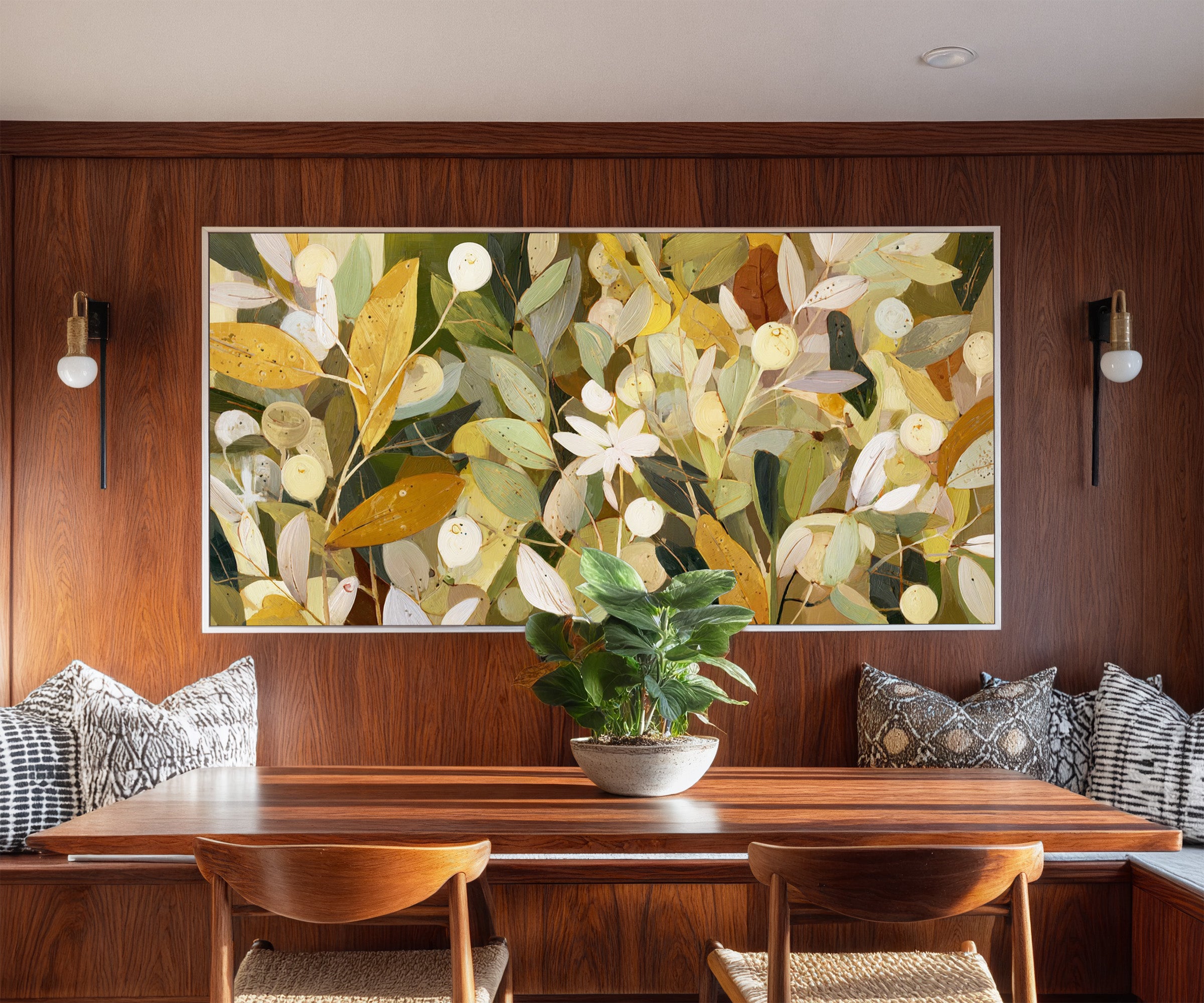 dense olive and gold leaf forms with pale canvas wall art in a white frame in a styled room setting