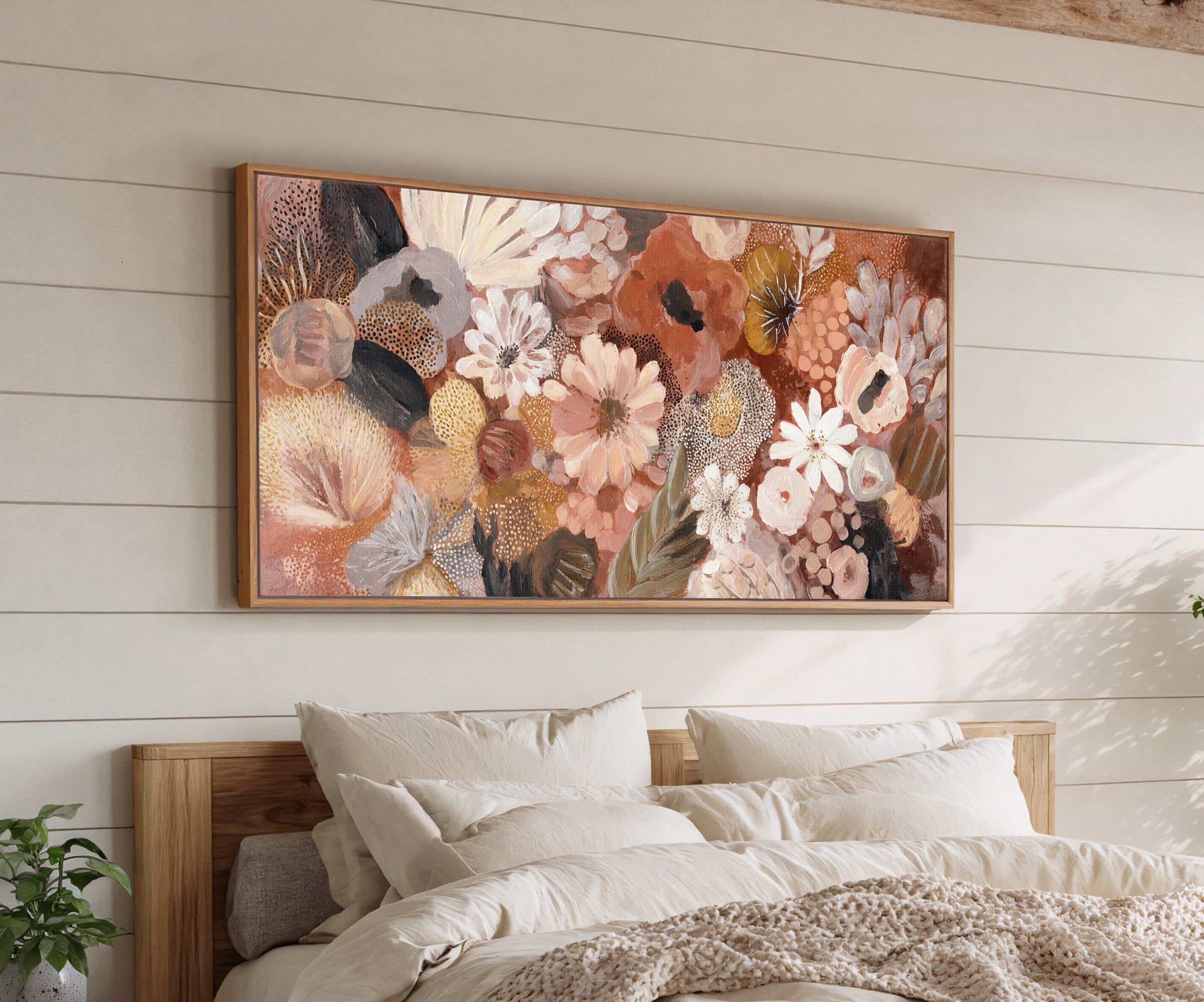 densely packed rounded florals in terracotta, canvas wall art in an oak frame above a bed